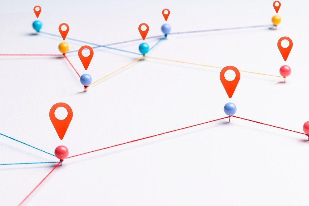Épingles de GPS reliées par des fils formant des itinéraires